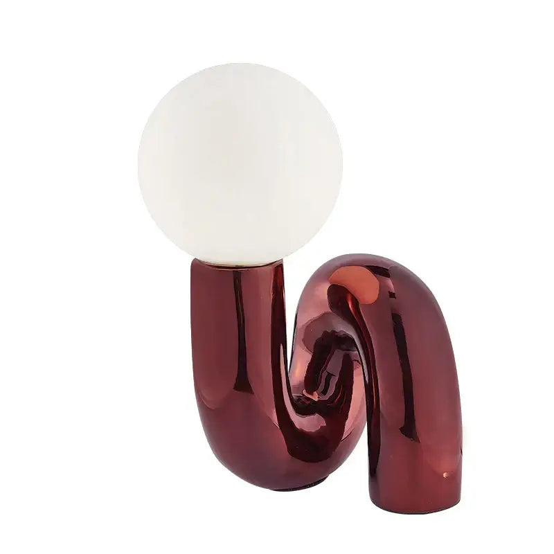 A sleek burgundy table lamp with a curved base and white glass ball shade for modern decorbites glass ball decor