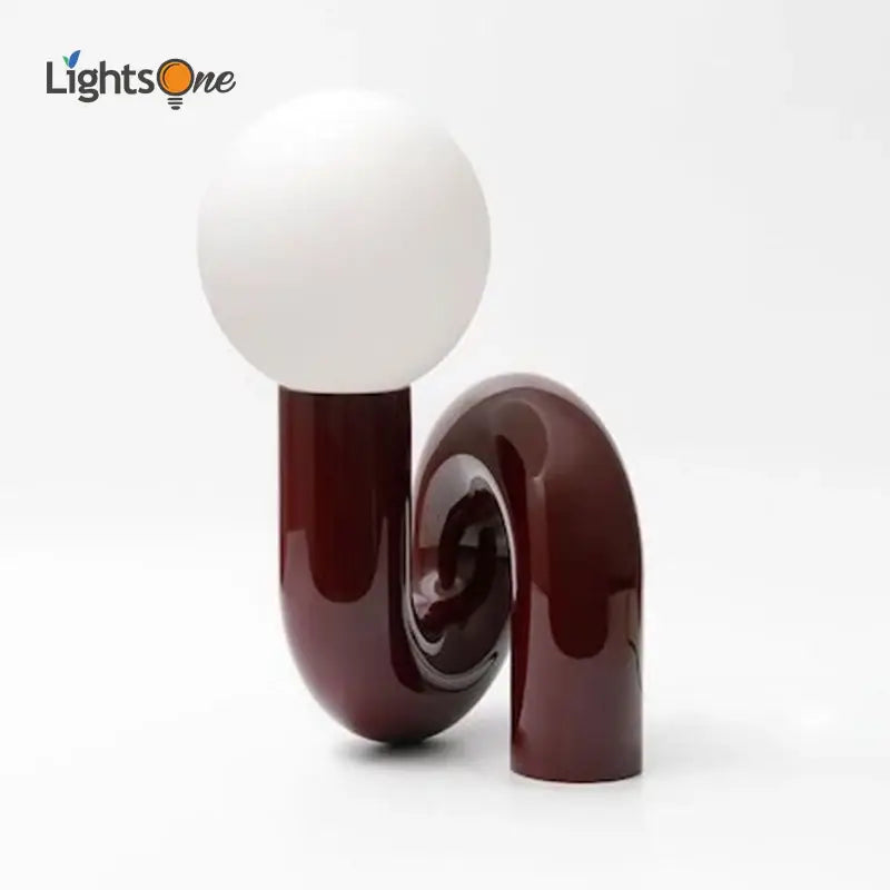 Modern burgundy and white decorbites glass ball table lamp with a sleek u-shaped base for bedroom use