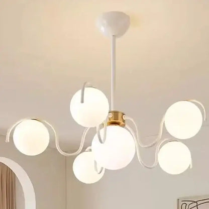 Modern white spherical globe pendant light with rounded glass arms and brass hub for dining room lighting