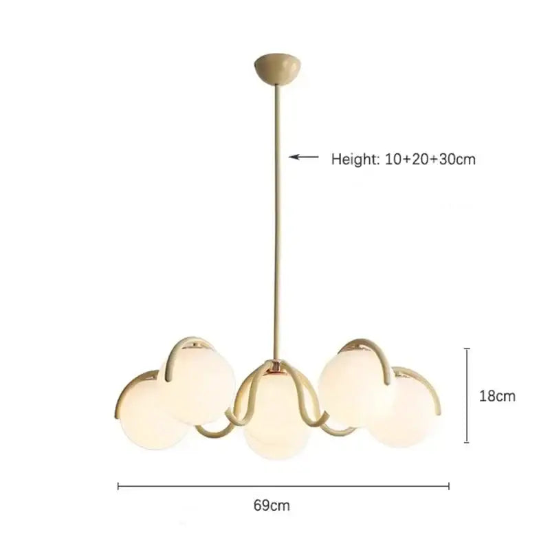 A modern pendant light with gold-toned metal and five frosted rounded glass globes for dining room use