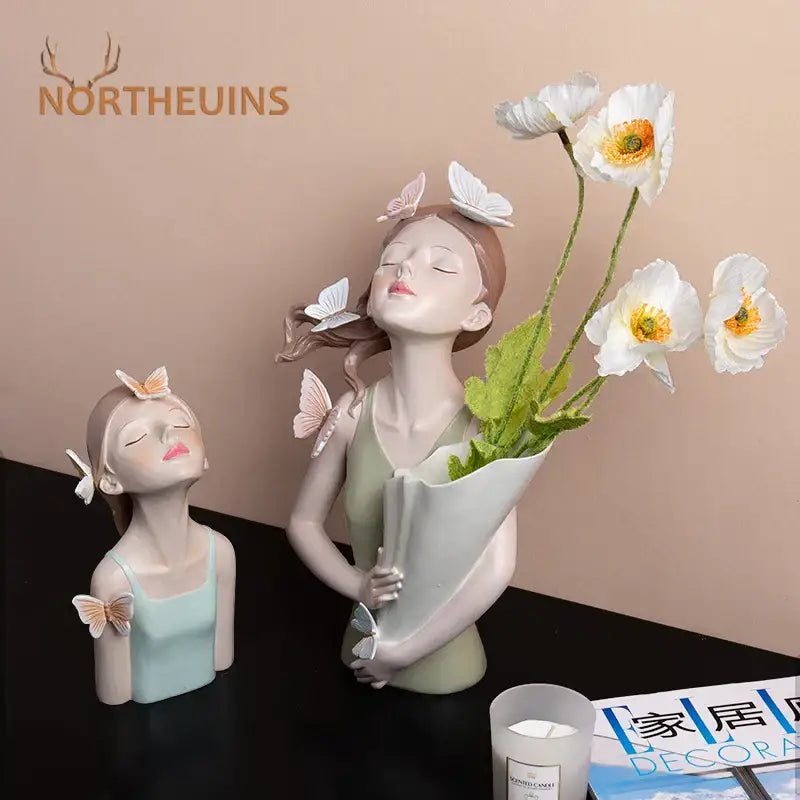 Modern butterfly girl resin sculpture of a delicate woman holding white poppies in light green wrap with butterfly girl resin decorbites accents