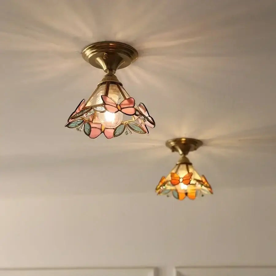 Modern butterfly glass tiffany ceiling light with stained glass butterflies in pink and orange framed by brass hardware
