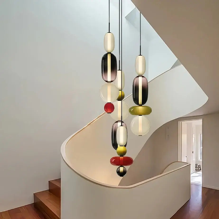 Modern candy glass ceiling hanging chandelier with stacked black and white glass orbs accented by red yellow gold spheres