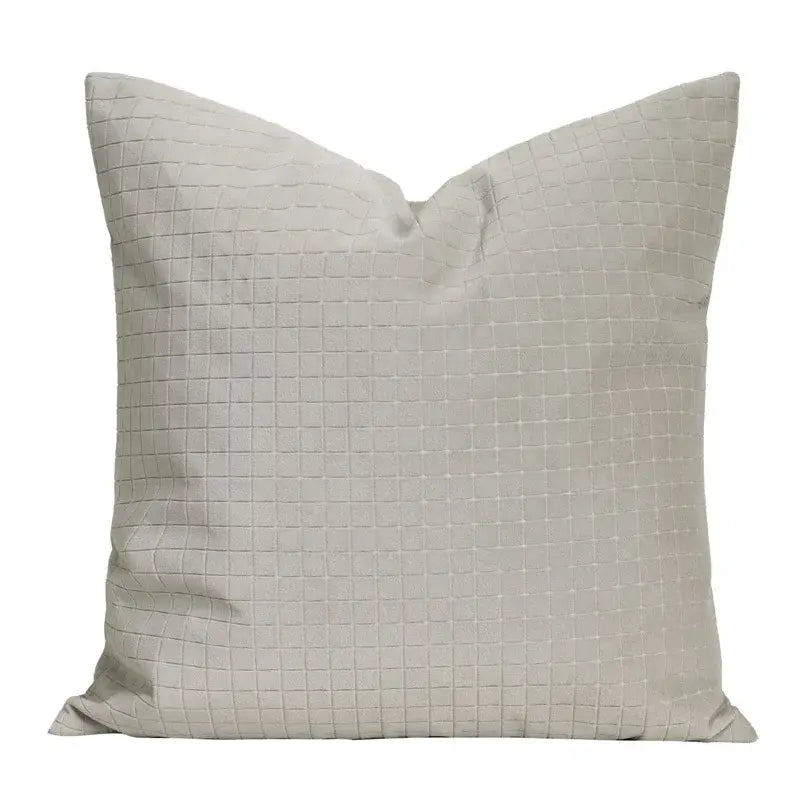 A square light gray cushion with a subtle quilted grid pattern and cappuccino tone geometry embroidery decorbites pillow