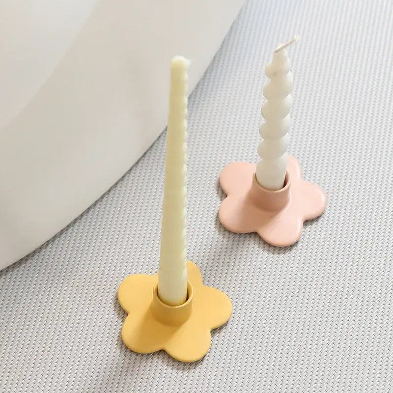 Pastel-colored matte candle holder in yellow and pink cartoon flower design holding white wax candles for bedroom decor