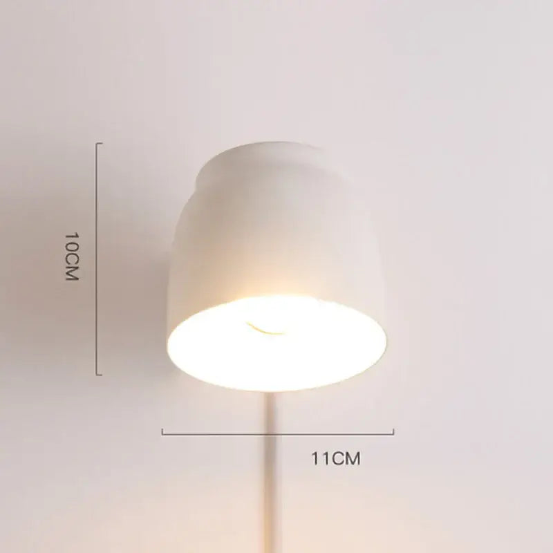Minimalist white ceramic led wall lamp with sleek tapered shade and slender stem as modern bedroom light source