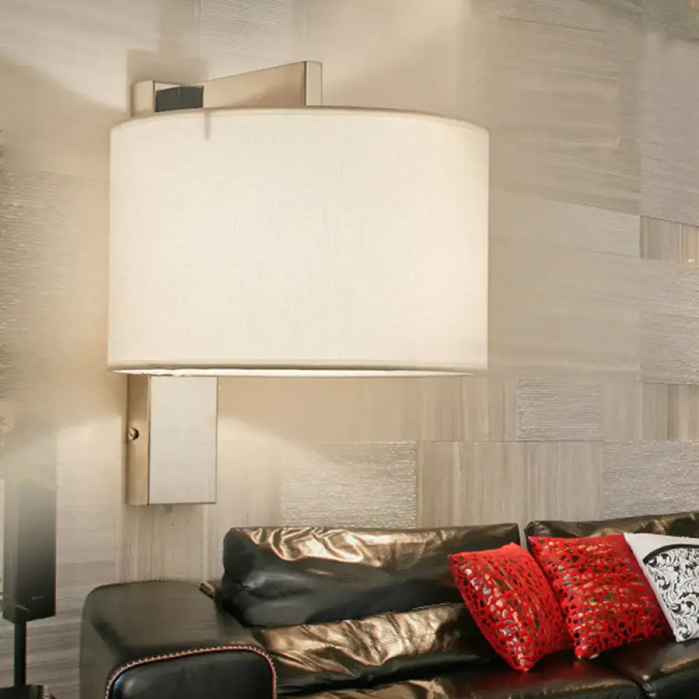 Modern white black drum wall sconce with a cylindrical fabric shade and sleek metallic rectangular base for bedroom lighting
