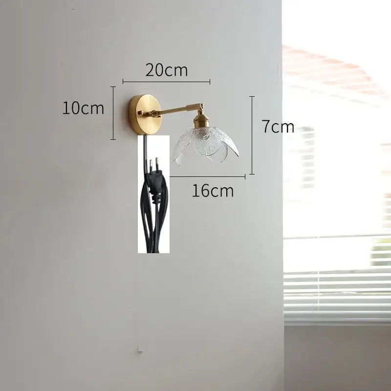 Gold-toned wall light with a clear textured glass shade shaped like an open flower for modern green glass led wall use