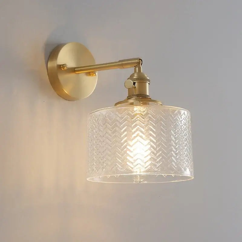 A brass-finished wall light with green glass led shade featuring embossed chevron pattern and pull chain switch