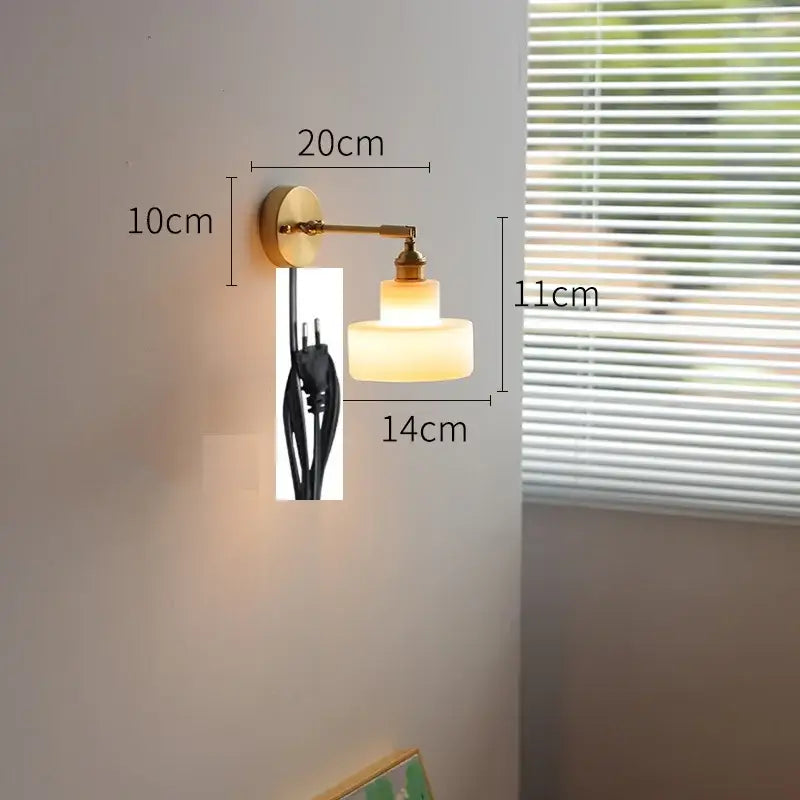 Modern chevron green glass led wall light with warm-toned two-tiered glass and brass-finished metal arm and base