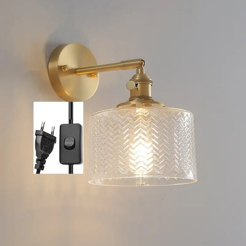 Gold-toned wall light with a clear green glass led shade featuring an embossed chevron pattern and pull chain switch