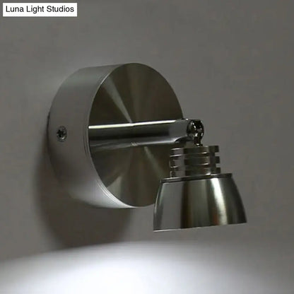 Modern chrome adjustable spotlight wall sconce with brushed stainless steel metal shade emitting warm white light