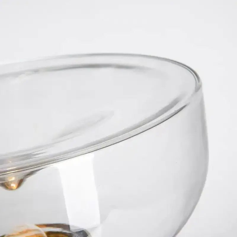Clear glass bowl with smooth rounded rim and golden accents as part of modern chrome decorbites aella glass table lamp