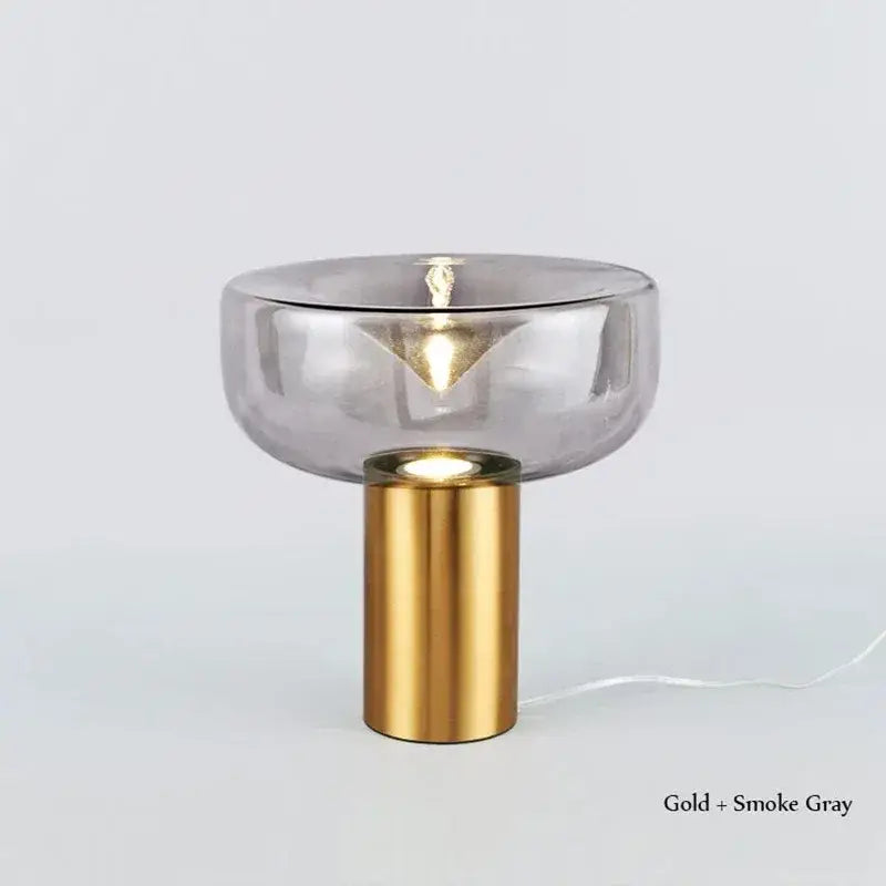 A sleek modern chrome aella glass table lamp with a gold base and smoke gray glass shade for bedroom decorbites decor