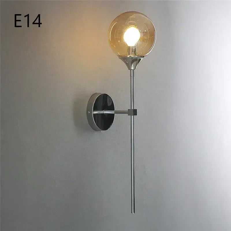 A sleek modern wall lamp with polished chrome finish and amber glass ball for elegant living room lighting decorbites glass ball