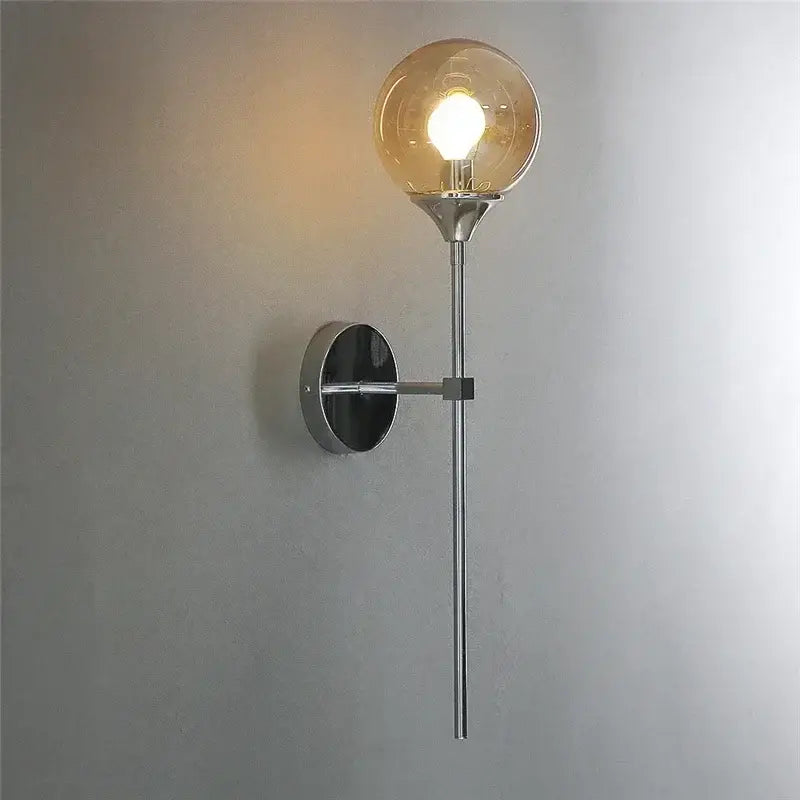 A sleek modern chrome wall lamp featuring an amber glass ball for stylish living room lighting decorbites wall lamps