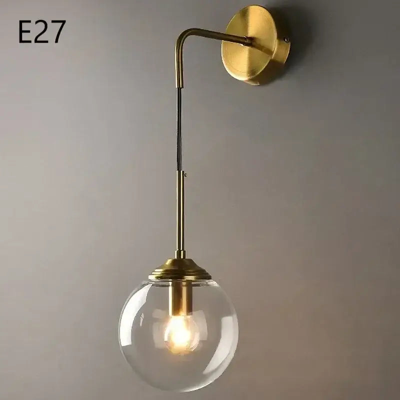 Brass-finished wall lamp with clear glass ball globe housing illuminated bulb for modern living room decorbites glass ball
