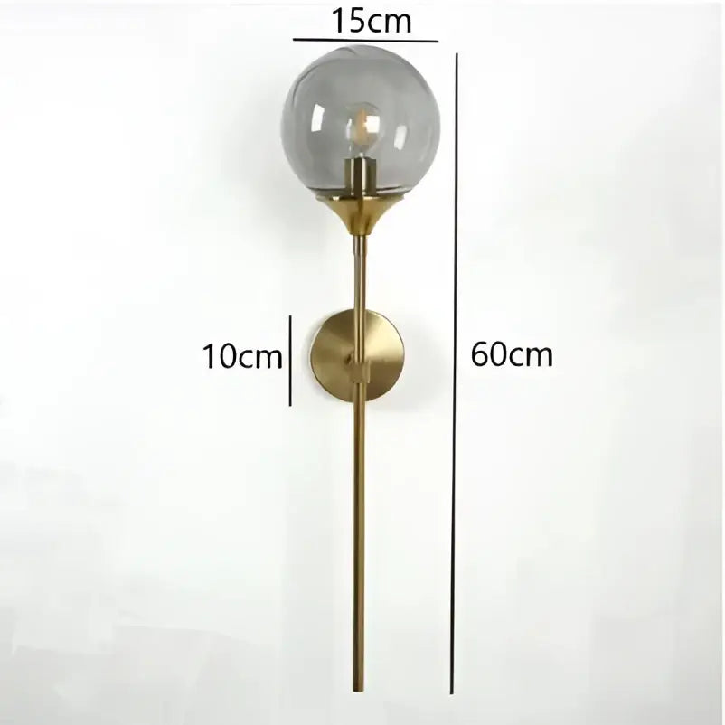 A sleek brass wall lamp with a smoked glass ball and exposed filament bulb for living room decorbites glass ball