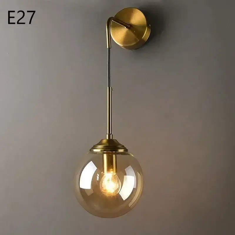 Modern chrome and amber glass ball wall lamps feature a gold-toned wall sconce with a spherical glass globe bulb decorbites glass ball
