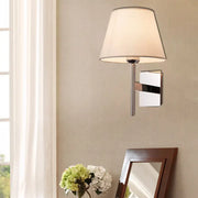 Modern chrome and beige fabric cone wall light with a soft fabric shade designed for bedroom use