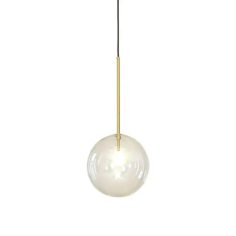 A modern pendant light with a clear glass globe, gold-toned metal rod, and black cord for kitchen lighting
