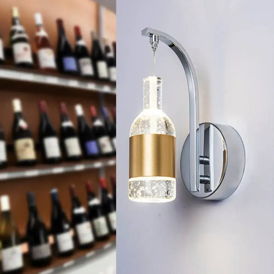 A modern chrome and gold seedy crystal wine bottle sconce with clear glass bottle and gold band for dining room