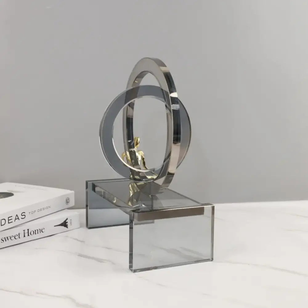 Modern chrome and golden rings golden man sculpture with interlocking geometric crystal rings on acrylic base for living room decor
