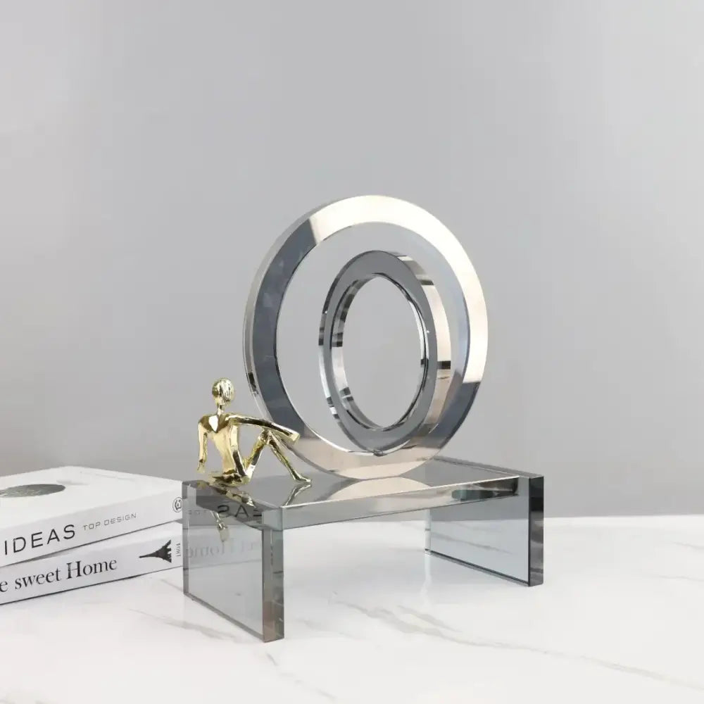 Modern chrome and golden man geometric crystal rings living room decor with a circular sculpture and golden figurine on a mirrored base