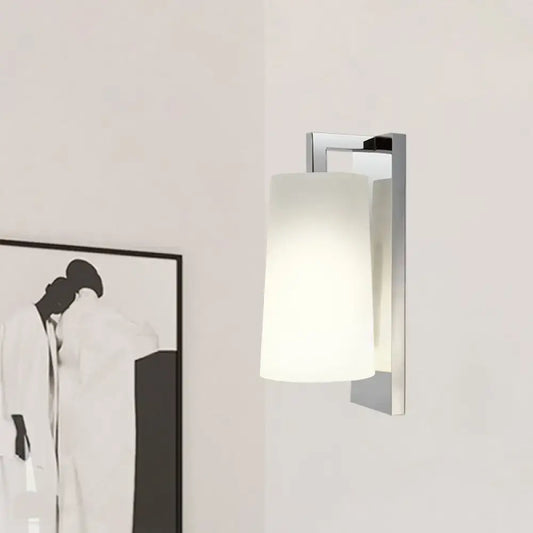 Modern chrome wall lamp with frosted white cylindrical glass shade and compact fixture height for bedroom use