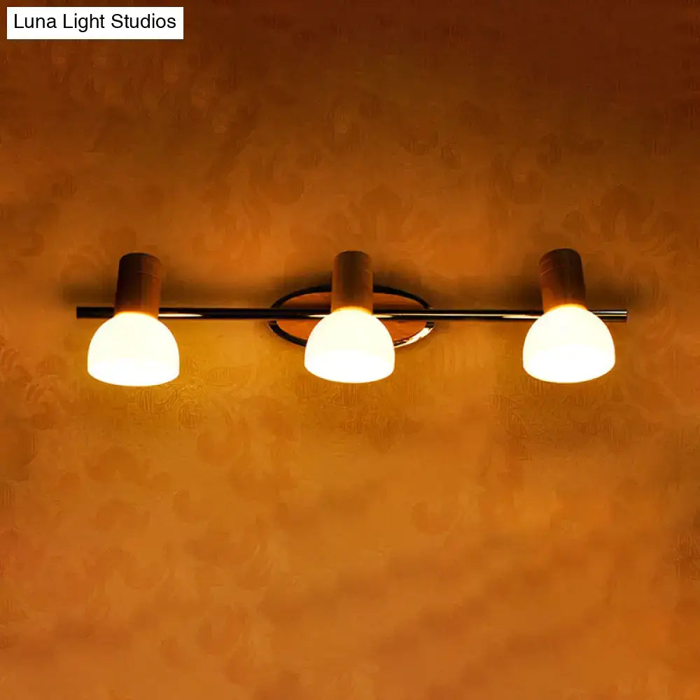 Modern three-light vanity fixture with chrome bar wooden accents and warm white glass dome shades for bathroom use