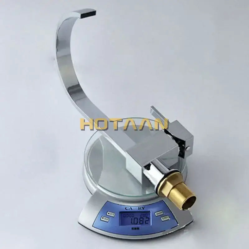 Modern chrome and brass dual hole kitchen tap with curved spout and brass threaded connection on a digital scale