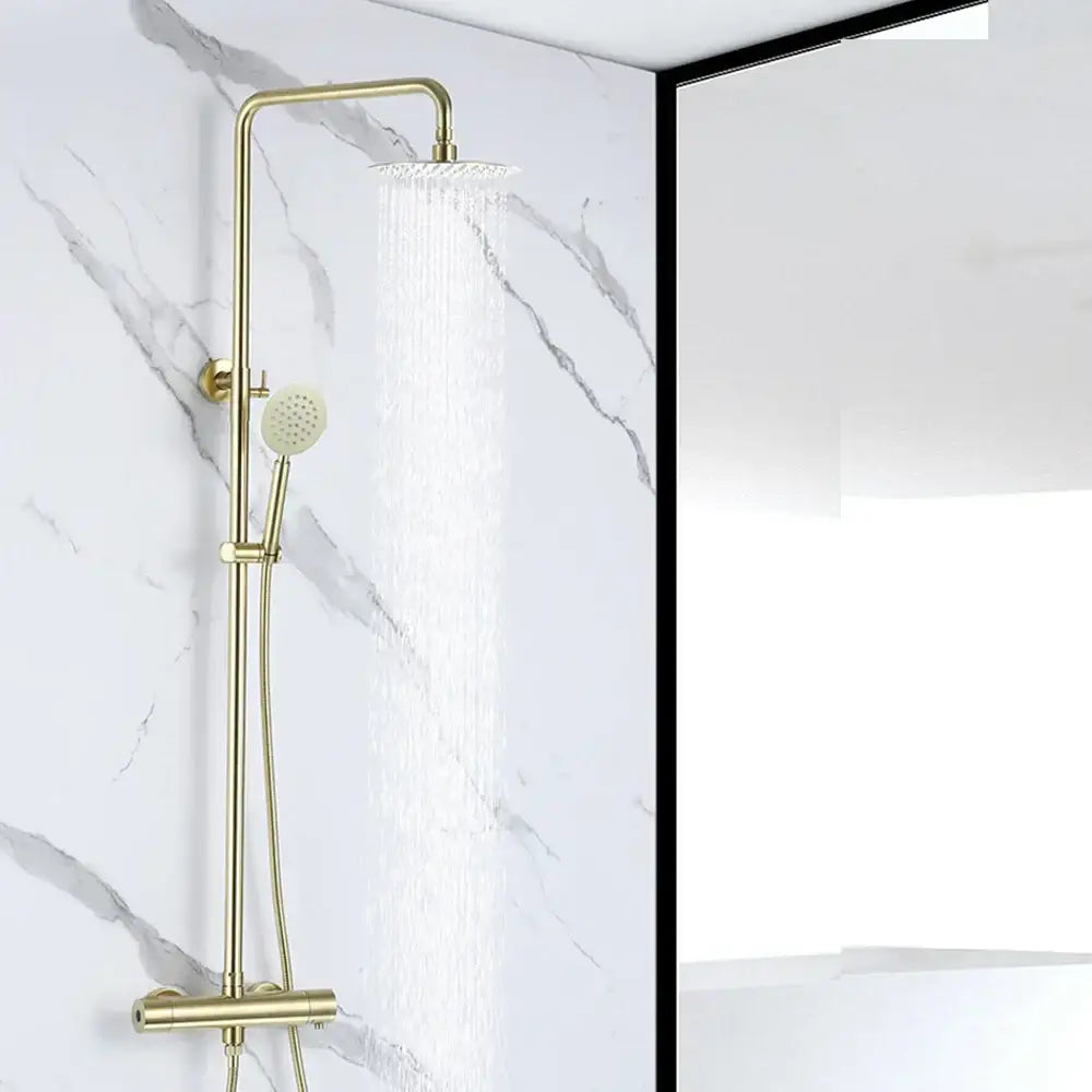Gold-toned brass shower mixer with rectangular rainfall head and handheld nozzle mounted on a dual handle vertical bar