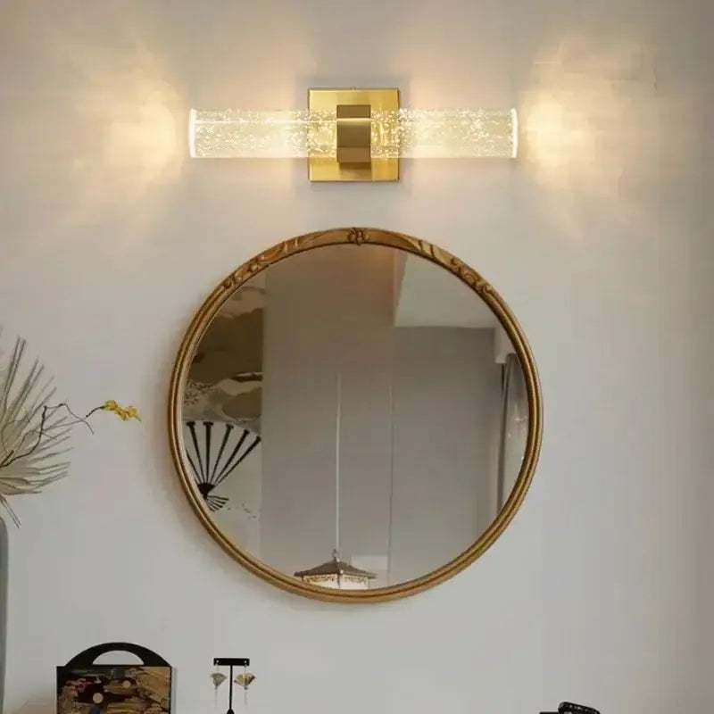 Gold-framed circular mirror with ornate detailing paired with decorbites bubble crystal led wall lamp for modern decor