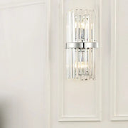 Modern chrome clear crystal cylinder wall sconce with vertical crystal rods and sleek chrome band for bedroom lighting