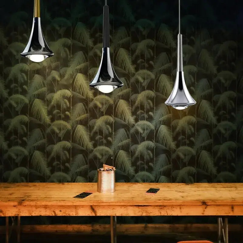 Three modern chrome conical led rain pendant lamps from decorbites lodes rain hang above a rustic wooden table