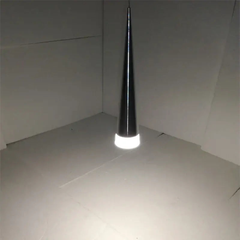 A sleek black decorbites conical pendant light with a glowing white circular base for modern living room decor
