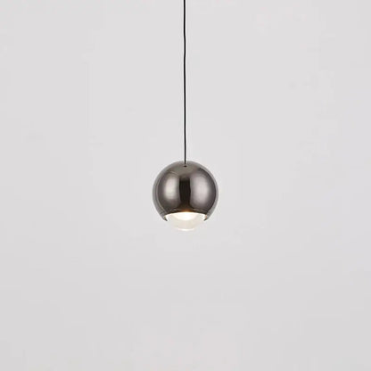 A modern chrome and copper ball pendant light with a brushed metallic finish and integrated warm glow for dining room