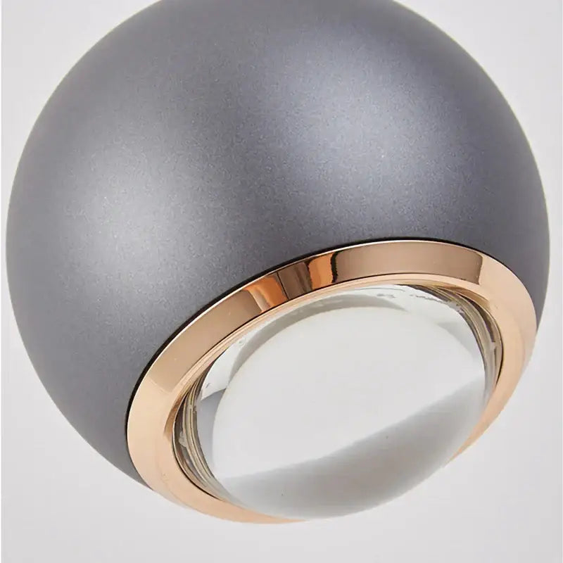 Matte gray ball pendant light with rose gold trim and clear glass lens for modern dining room chandelier lighting