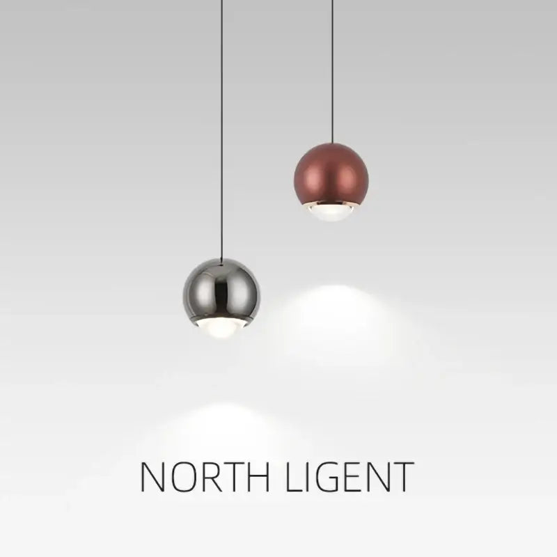 Two spherical pendant lights in polished chrome and matte copper tones for modern dining room lighting
