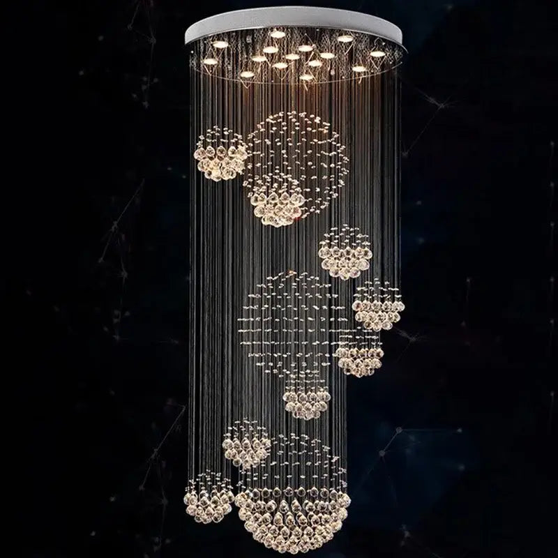 A modern chrome decorbites crystal ball chandelier with cascading clear faceted crystals and a white ceiling mount