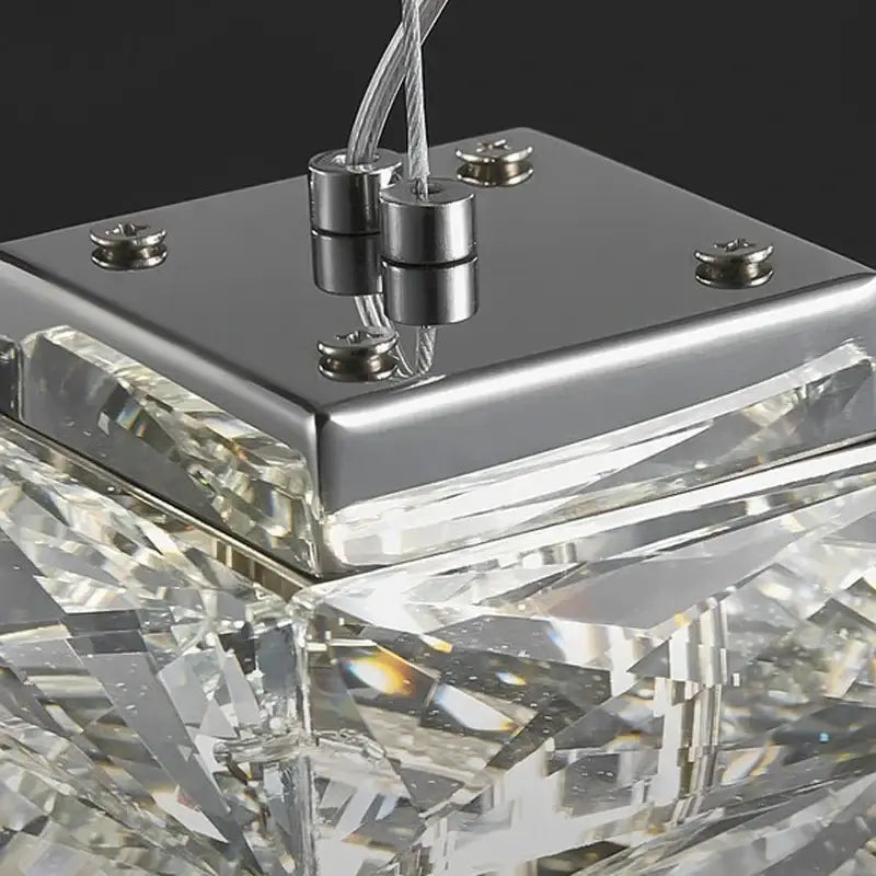 A modern chrome crystal dining table pendant lamp with faceted clear glass elements and sleek metal base for kitchen island decorbites crystal dining