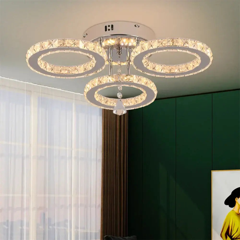 Modern chrome crystal flush mount ceiling light with three interlocking rings and dangling teardrop pendant for living room decorbites flush mount
