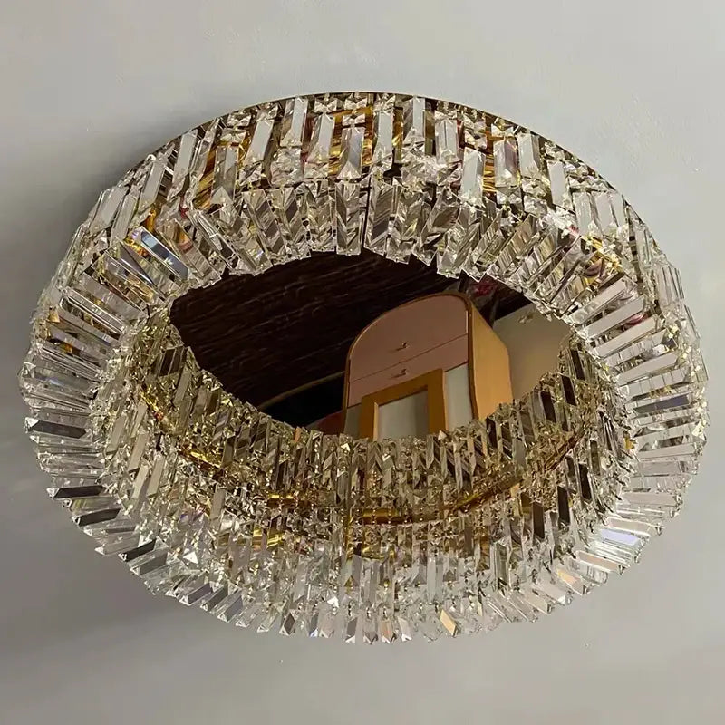 A modern chrome decorbites crystal led ceiling lamp featuring a circular mirror with clear crystal prism frame in gold tone