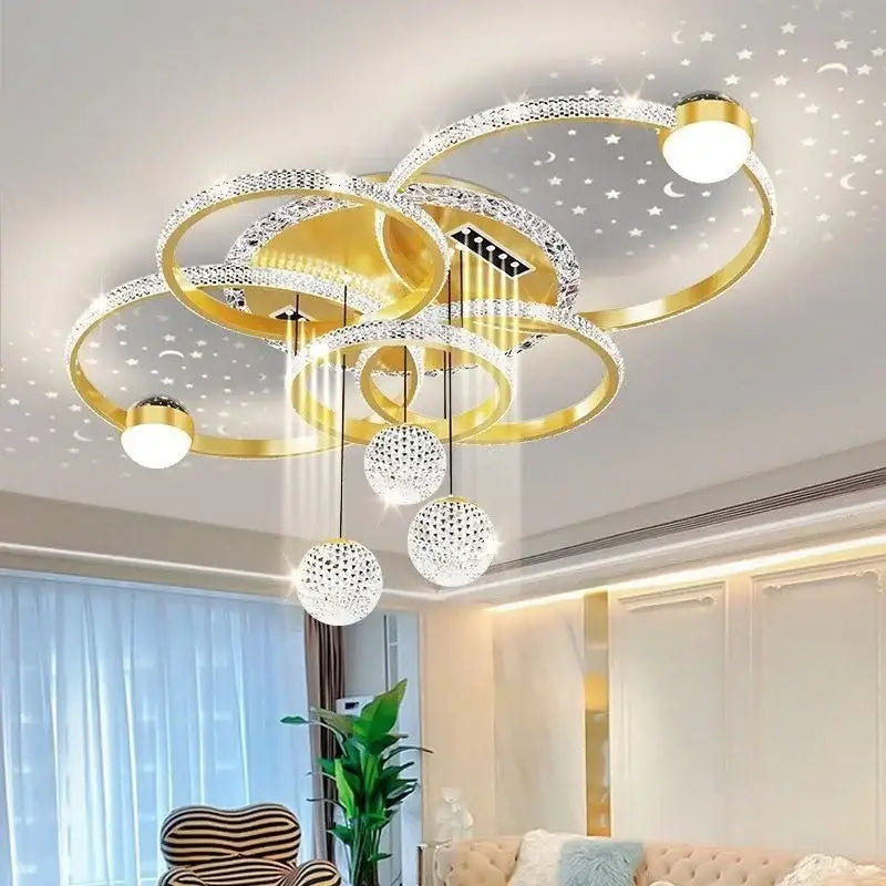 Gold-toned modern chrome led pendant chandelier with interlocking rings, crystal pendants, and starry moon motifs for dining room