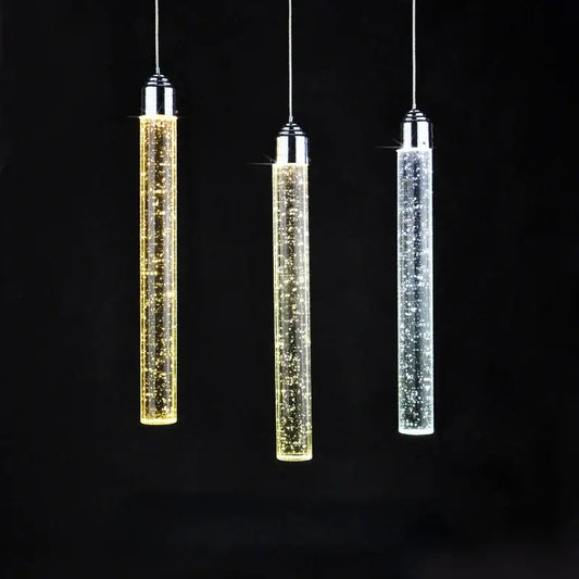 Three modern crystal led pendant lights with chrome tops and glass bodies glowing in gold warm white and cool white hues