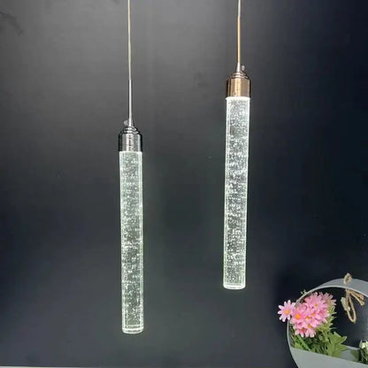 Two modern chrome decorbites crystal led pendant lights with clear glass bodies and metallic tops for dining room decor