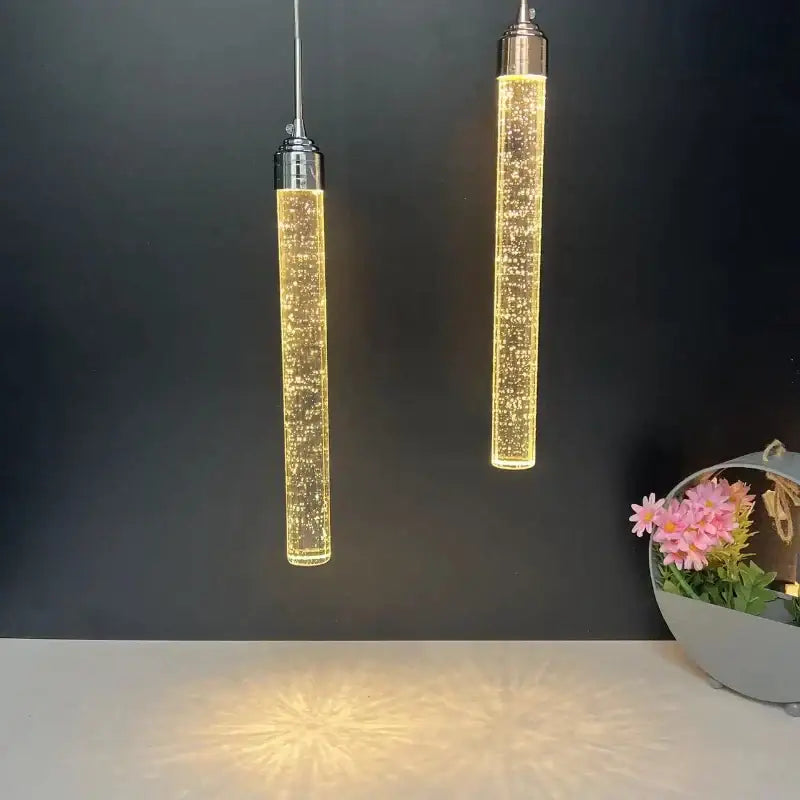 Two sleek cylindrical chrome crystal led pendant lights with warm golden glow for dining room decorbites crystal led design