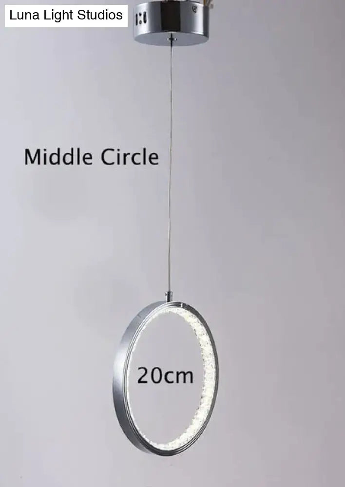 A sleek decorbites crystal rings led pendant light fixture with chrome finish and illuminated circular design for indoor use