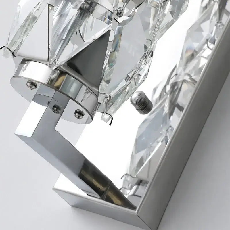 Modern chrome crystal wall lamp with faceted clear glass elements and polished metal frame for luxury bedroom decorbites lighting