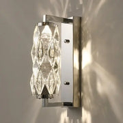 Modern chrome crystal wall lamp features a sleek frame with cascading clear crystal facets for luxury bedroom lighting decorbites wall lamp